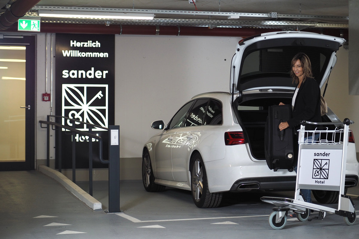 Unsere Tiefgarage mit einem großen Auto und im Hintergrund der Zugang zum Hotel